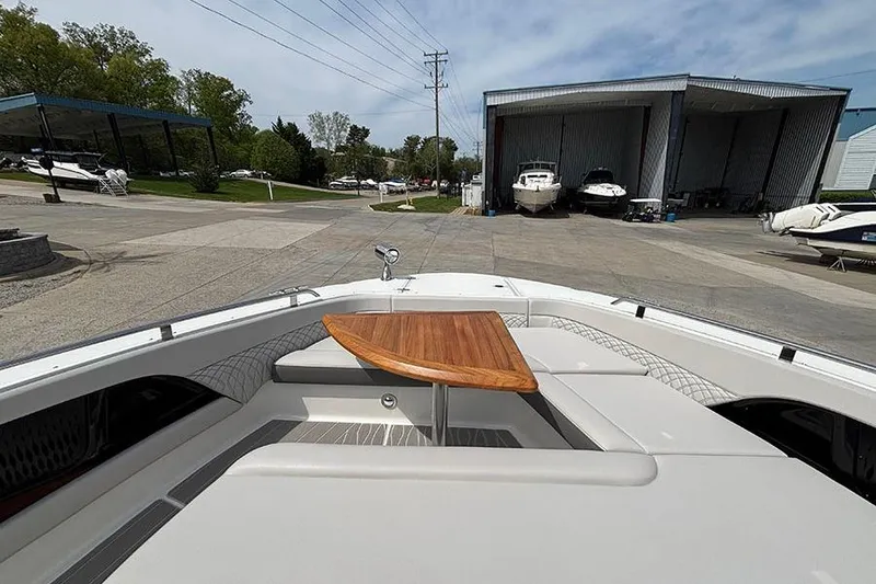 Slide: The Image of 2026 Sea Ray Sundancer 370 Outboard with wooden table, docked near boat storage facility. - 46