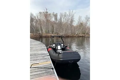Slide: The Image of 2025 Highfield Velox 420 boat docked on a calm lake with trees in the background. - 3