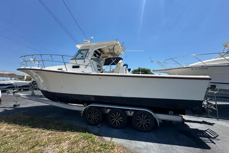 The Image of 1998 True World Marine TE286 boat on trailer under clear blue sky. - 0