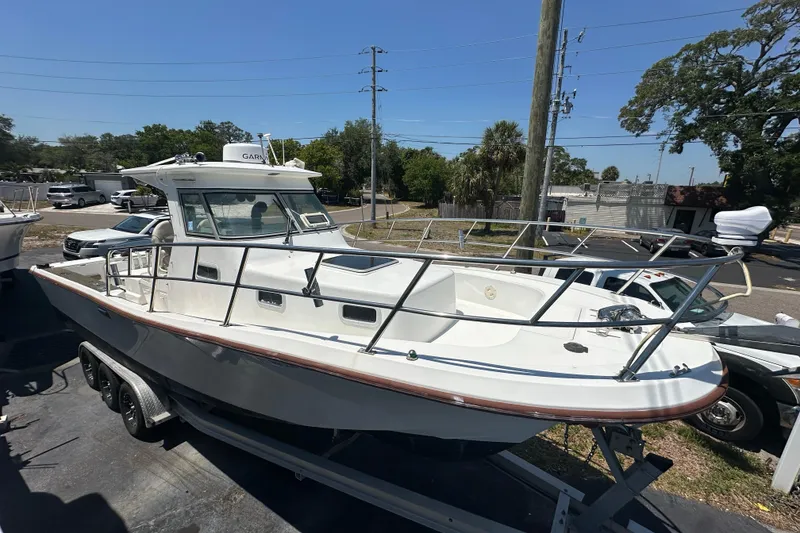 Slide: The Image of 1998 True World Marine TE286 boat on trailer, parked outdoors under clear sky. - 3