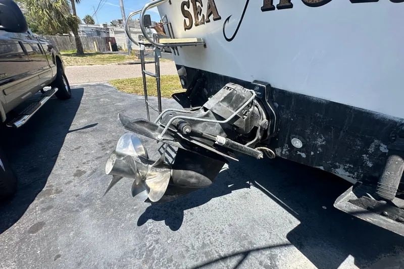 Slide: The Image of 1998 True World Marine TE286 boat with dual propellers and ladder, parked on pavement. - 5