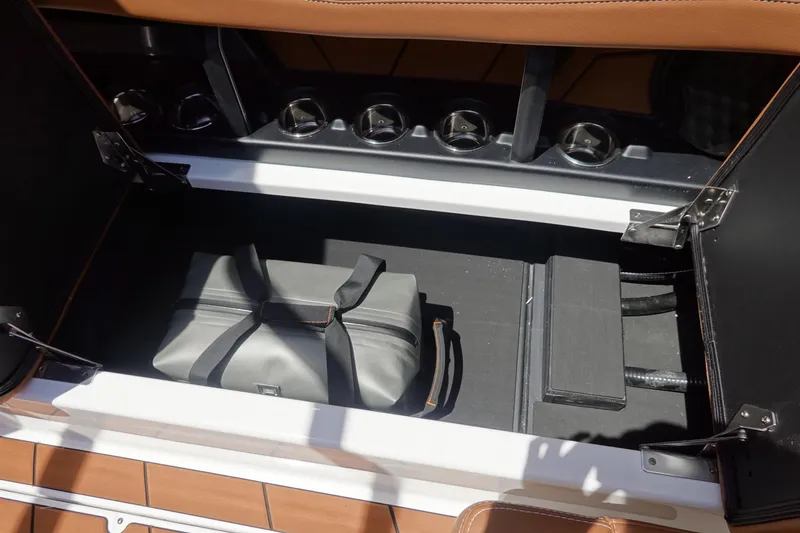 Slide: The Image of Storage compartment in 2026 Malibu Wakesetter 21 LX with a gray bag inside. - 22