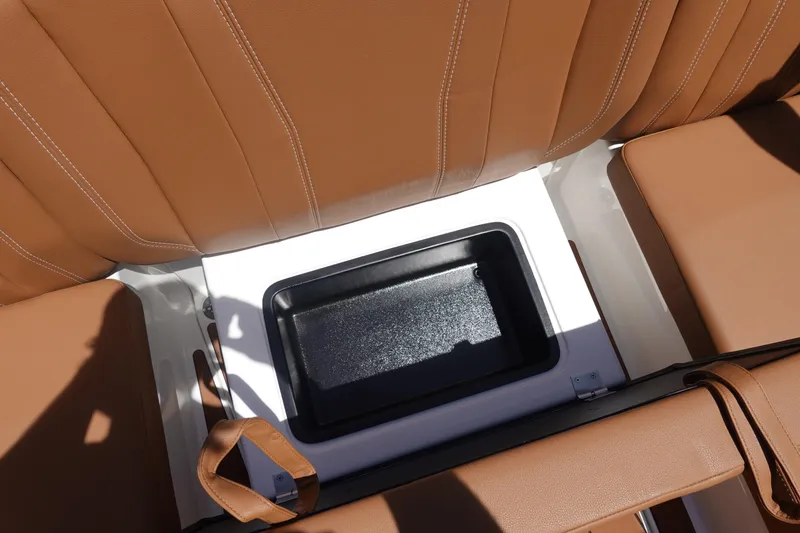 Slide: The Image of 2026 Malibu Wakesetter 21 LX interior storage compartment with tan leather seating. - 24