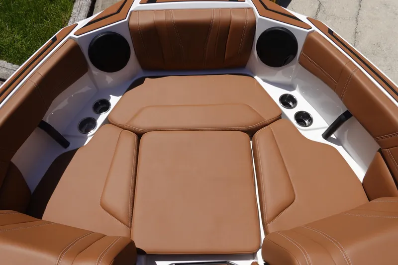Slide: The Image of 2026 Malibu Wakesetter 21 LX boat interior with brown leather seating and cup holders. - 32