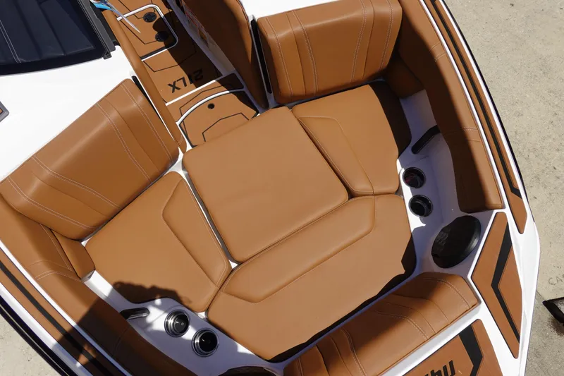 Slide: The Image of 2026 Malibu Wakesetter 21 LX boat interior with tan leather seating and cup holders. - 33