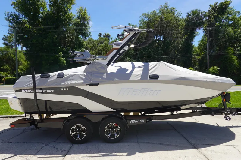 Slide: The Image of 2026 Malibu Wakesetter 21 LX boat on trailer, covered, parked outdoors. - 38