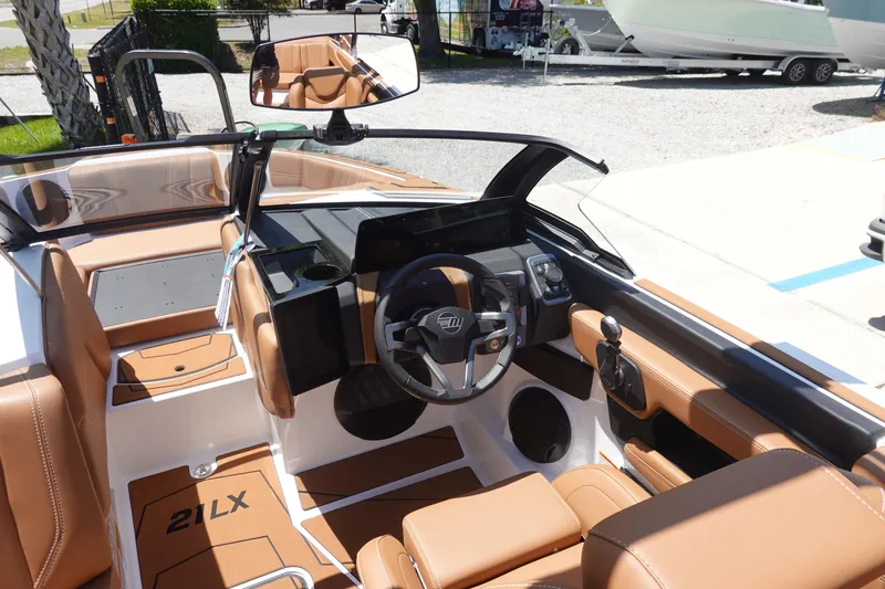 Slide: The Image of 2026 Malibu Wakesetter 21 LX boat interior with tan leather seats and modern dashboard. - 9