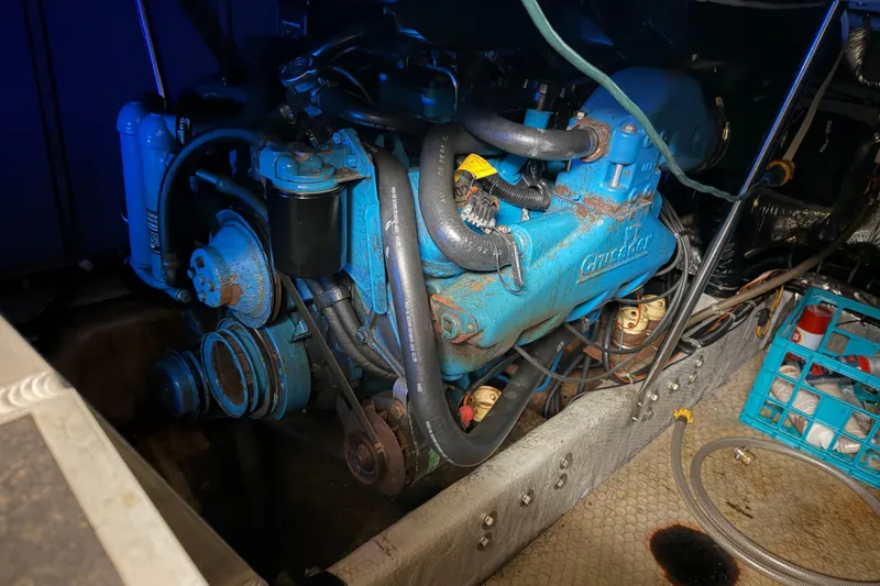 Slide: The Image of Engine compartment of a 1997 Silverton 442 Cockpit Motor Yacht, featuring a blue Crusader engine. - 11