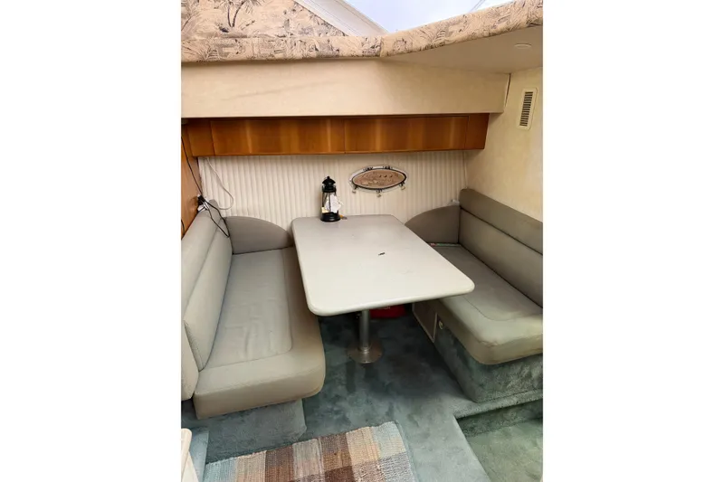 Slide: The Image of 1997 Silverton 442 Cockpit Motor Yacht interior with cozy dining area and seating. - 17
