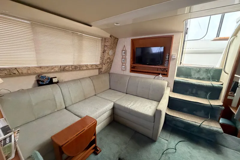 Slide: The Image of Interior of 1997 Silverton 442 Cockpit Motor Yacht with sofa, TV, and stairs. - 26