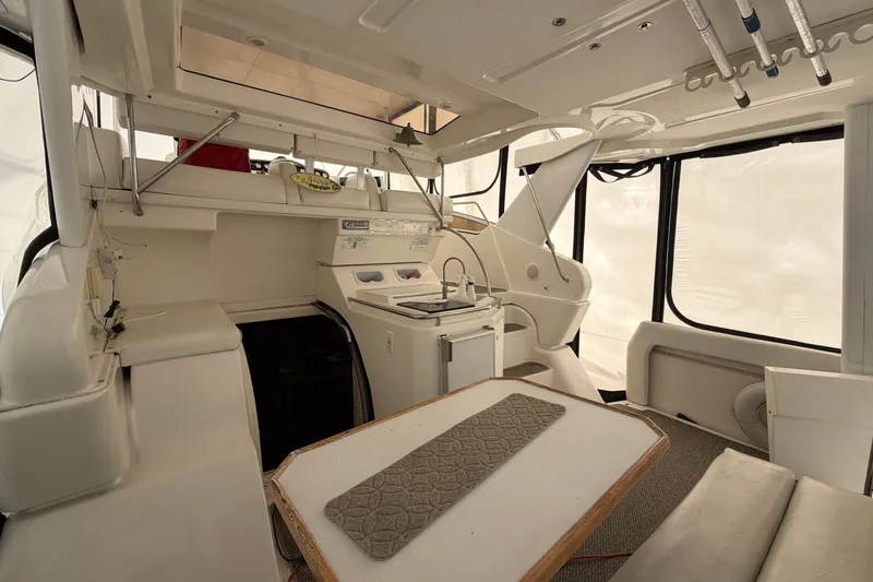Slide: The Image of 1997 Silverton 442 Cockpit Motor Yacht interior with helm, seating, and kitchenette. - 31