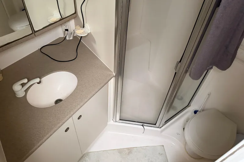 Slide: The Image of Bathroom interior of 1997 Silverton 442 Cockpit Motor Yacht with shower, sink, and toilet. - 34
