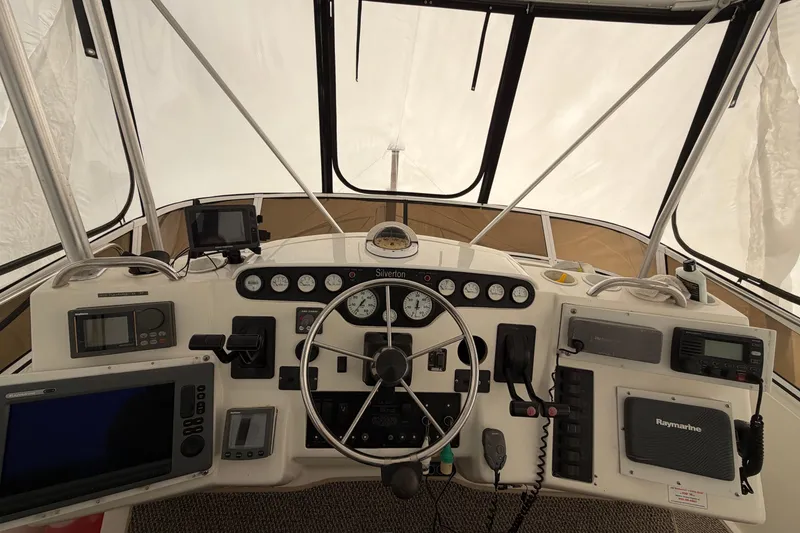 Slide: The Image of Cockpit view of a 1997 Silverton 442 Motor Yacht with navigation instruments and steering wheel. - 4