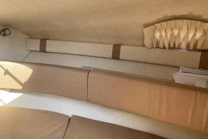 Slide: The Image of Interior cabin of 2011 Sea Ray 240 Sundancer with beige upholstery and curtain. - 18