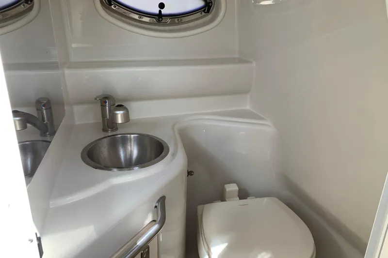 Slide: The Image of Interior of 2011 Sea Ray 240 Sundancer boat bathroom with sink and toilet. - 23