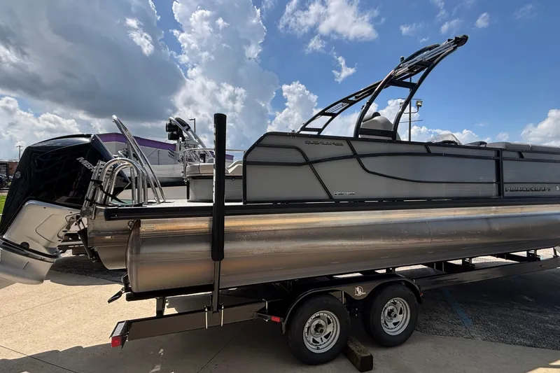 Slide: The Image of 2023 Princecraft Quorum 25 RL pontoon boat on trailer under a cloudy sky. - 13