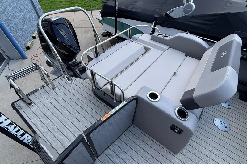 Slide: The Image of 2023 Princecraft Quorum 25 RL pontoon boat with seating and motor, docked on a sunny day. - 19