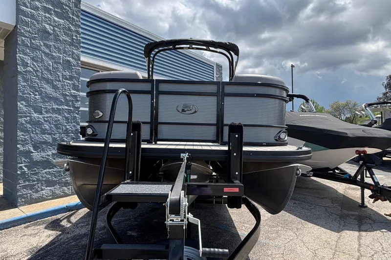 Slide: The Image of 2023 Princecraft Quorum 25 RL pontoon boat on trailer under cloudy sky. - 3