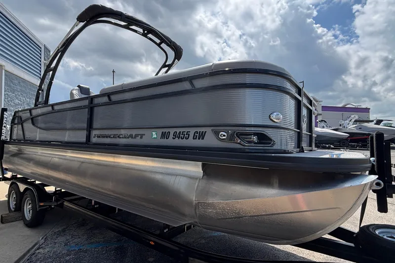 Slide: The Image of 2023 Princecraft Quorum 25 RL pontoon boat on trailer under cloudy sky. - 4