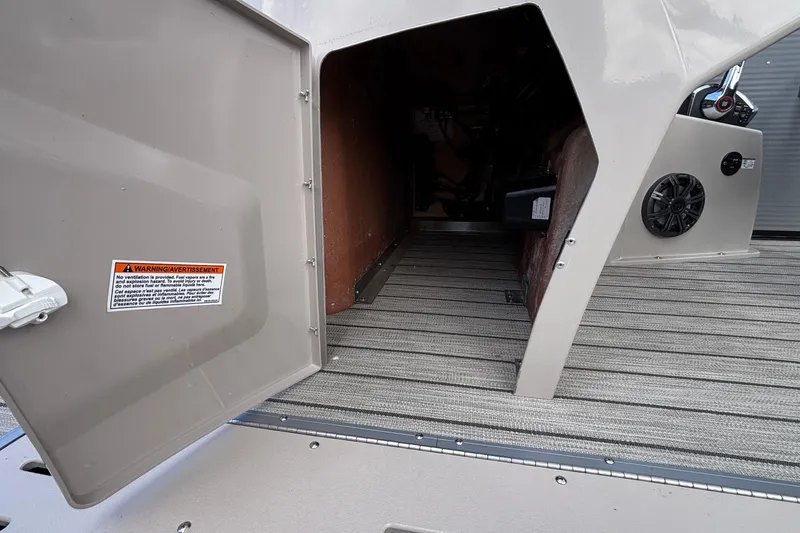 Slide: The Image of 2023 Princecraft Quorum 25 RL storage compartment with open door and warning label. - 40