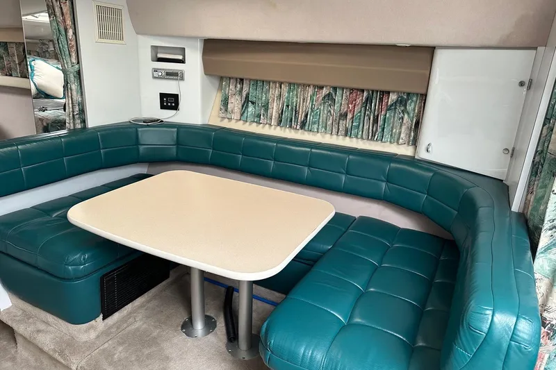 Slide: The Image of Interior of a 1997 Formula 34 Performance Cruiser with teal seating and a beige table. - 20