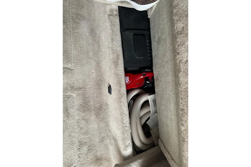 Slide: The Image of Storage compartment in a 1997 Formula 34 Performance Cruiser with vacuum and hose. - 23