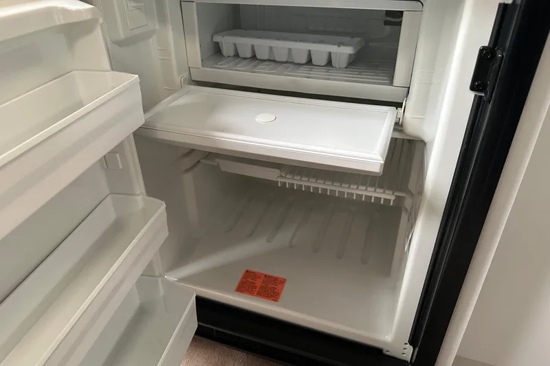 Slide: The Image of Empty refrigerator interior with ice tray, part of a 1997 Formula 34 Performance Cruiser. - 24