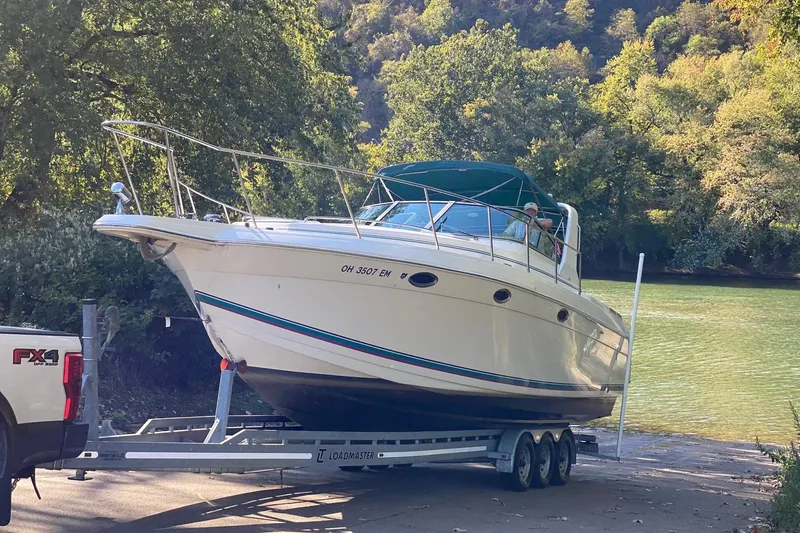 Slide: The Image of 1997 Formula 34 Performance Cruiser on trailer near scenic riverbank. - 5