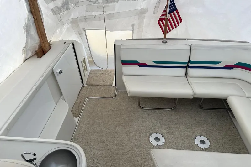 Slide: The Image of Interior of a 1997 Formula 34 Performance Cruiser with white seating and American flag. - 6