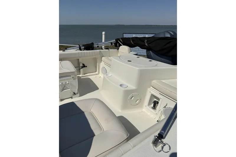 Slide: The Image of 2004 Hydra-Sports Lightning 202 DC boat interior with seating and storage, overlooking calm waters. - 2