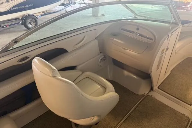 Slide: The Image of Interior of a 2002 Chaparral 216 SSi boat, featuring beige seating and dashboard. - 10