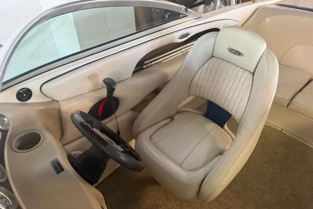Slide: The Image of Interior of a 2002 Chaparral 216 SSi boat, featuring a sleek steering wheel and comfortable seating. - 11