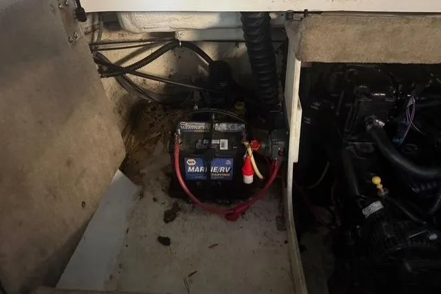 Slide: The Image of Battery compartment of a 2002 Chaparral 216 SSi boat, featuring wiring and engine components. - 17