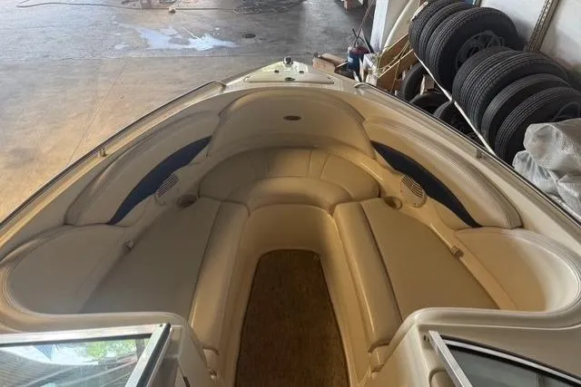 Slide: The Image of 2002 Chaparral 216 SSi boat interior with beige seating in a garage setting. - 6