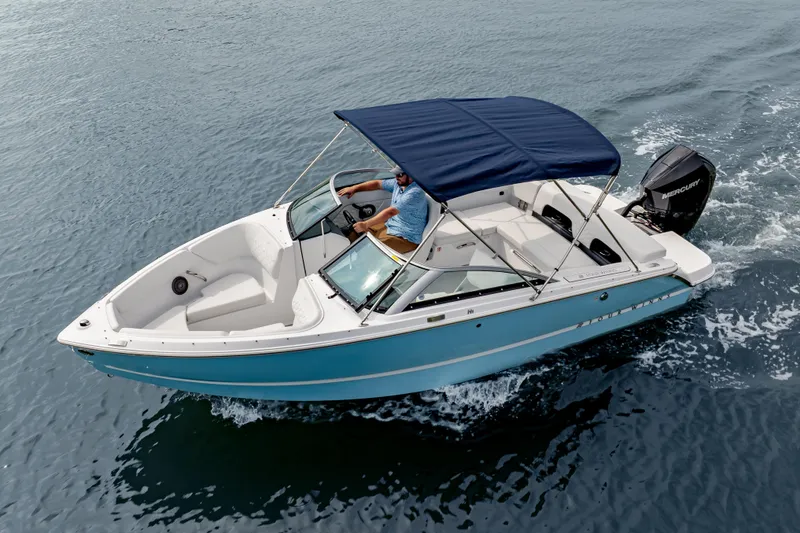 Slide: The Image of 2026 Four Winns H1 OB boat cruising on water with blue canopy and outboard motor. - 3