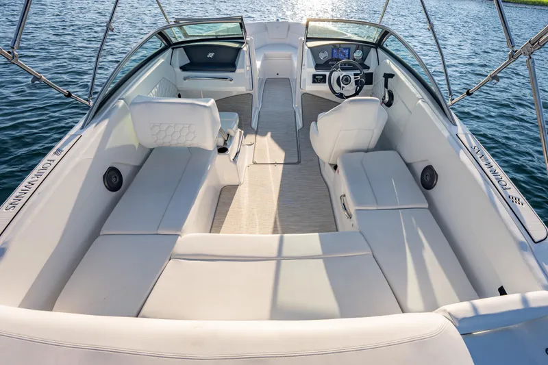 Slide: The Image of 2026 Four Winns H1 OB boat interior with spacious seating and modern dashboard on water. - 13