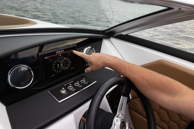 Slide: The Image of 2026 Four Winns H1 OB dashboard with Simrad display and steering wheel on water. - 5