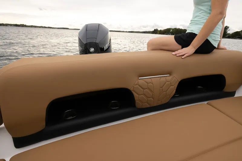 Slide: The Image of 2026 Four Winns H1 OB boat with tan seating, person relaxing by the water. - 7