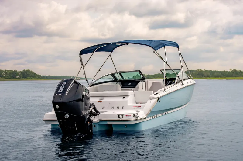 Slide: The Image of A sleek motorboat with a blue canopy and powerful outboard motor on calm water. - 9