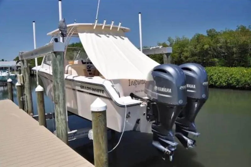 The Image of 2014 Grady-White Freedom 275 boat with twin Yamaha engines docked by a pier. - 1