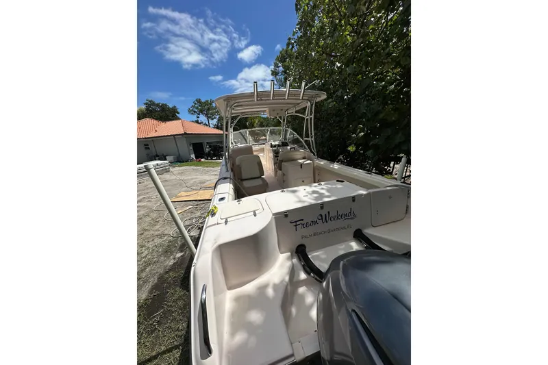 Slide: The Image of 2014 Grady-White Freedom 275 boat docked, sunny day, lush greenery, clear blue sky. - 13