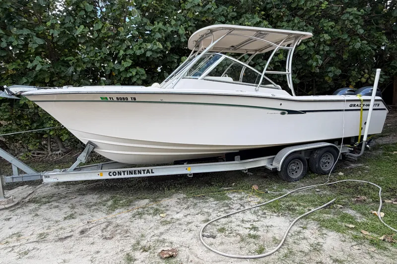 Slide: The Image of 2014 Grady-White Freedom 275 boat on trailer, parked outdoors near greenery. - 15
