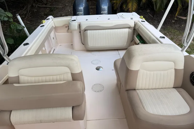 Slide: The Image of 2014 Grady-White Freedom 275 boat interior with cushioned seating and twin 200 engines. - 23