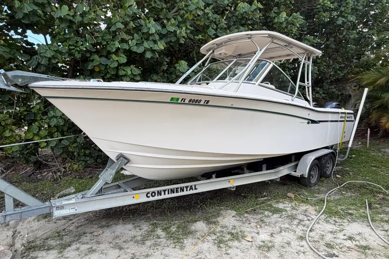 Slide: The Image of 2014 Grady-White Freedom 275 boat on trailer, surrounded by lush greenery. - 36