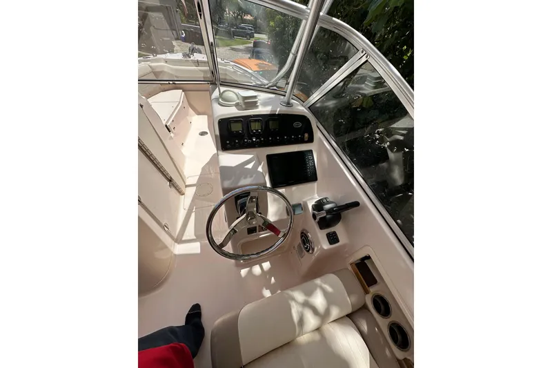 Slide: The Image of 2014 Grady-White Freedom 275 boat cockpit with steering wheel and control panel. - 7