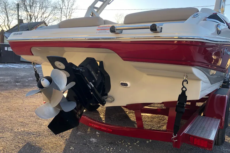 Slide: The Image of 2020 Crownline 235 SS boat rear view with propeller and red trailer. - 14