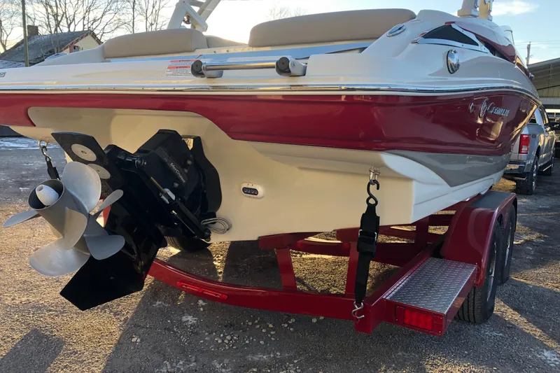 Slide: The Image of 2020 Crownline 235 SS boat on trailer, rear view showing propeller and red accents. - 15