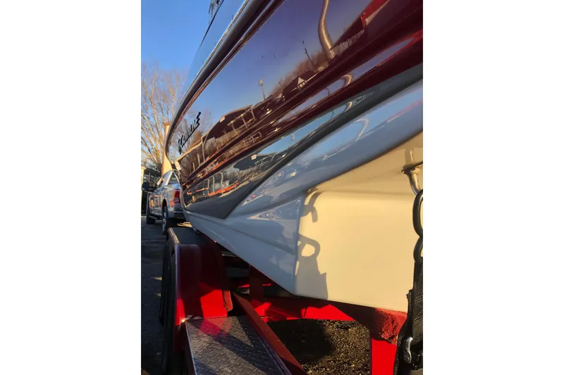 Slide: The Image of 2020 Crownline 235 SS boat on trailer, reflecting sunlight. - 22