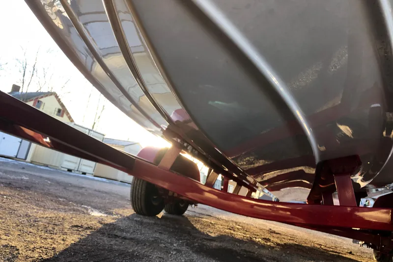 Slide: The Image of 2020 Crownline 235 SS boat on trailer, sunlit, showcasing hull design. - 26