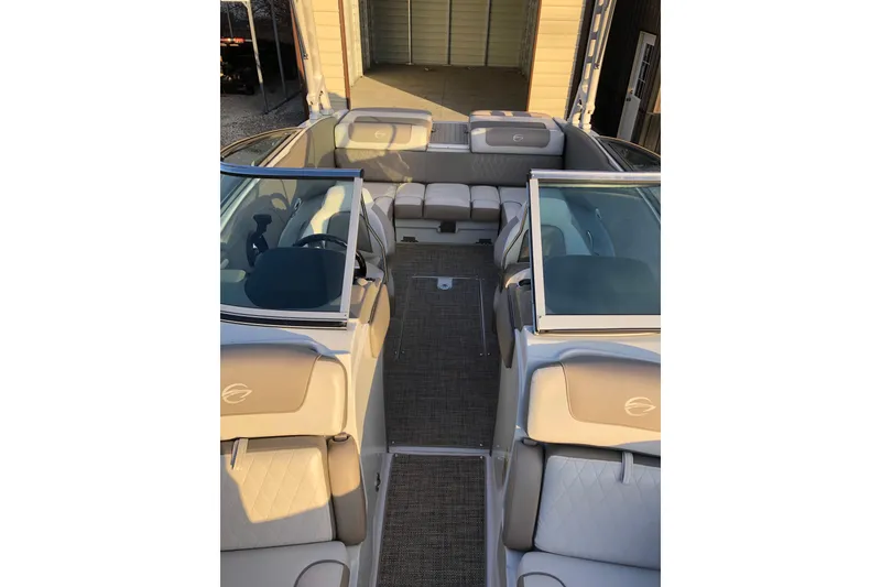 Slide: The Image of 2020 Crownline 235 SS boat interior with beige seating and glass windshields. - 31